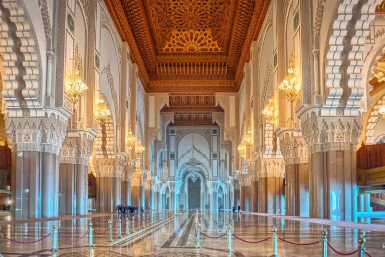 Intérieur de la salle de prière de la mosquée Hassan II à Casablanca : arcades, plafond en cèdre sculpté, lustres et sol en marbre