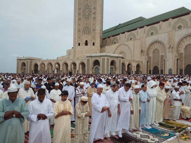 Grande prière collective de l'Aïd al-Fitr sur l'esplanade de la mosquée Hassan II à Casablanca, fidèles en djellabas blanches alignés au matin de l'Aïd