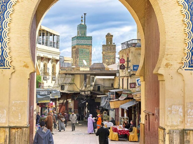 Vue à travers la porte Bab Bou Jeloud (Porte Bleue) de Fès sur la médina animée et les minarets en zellige vert